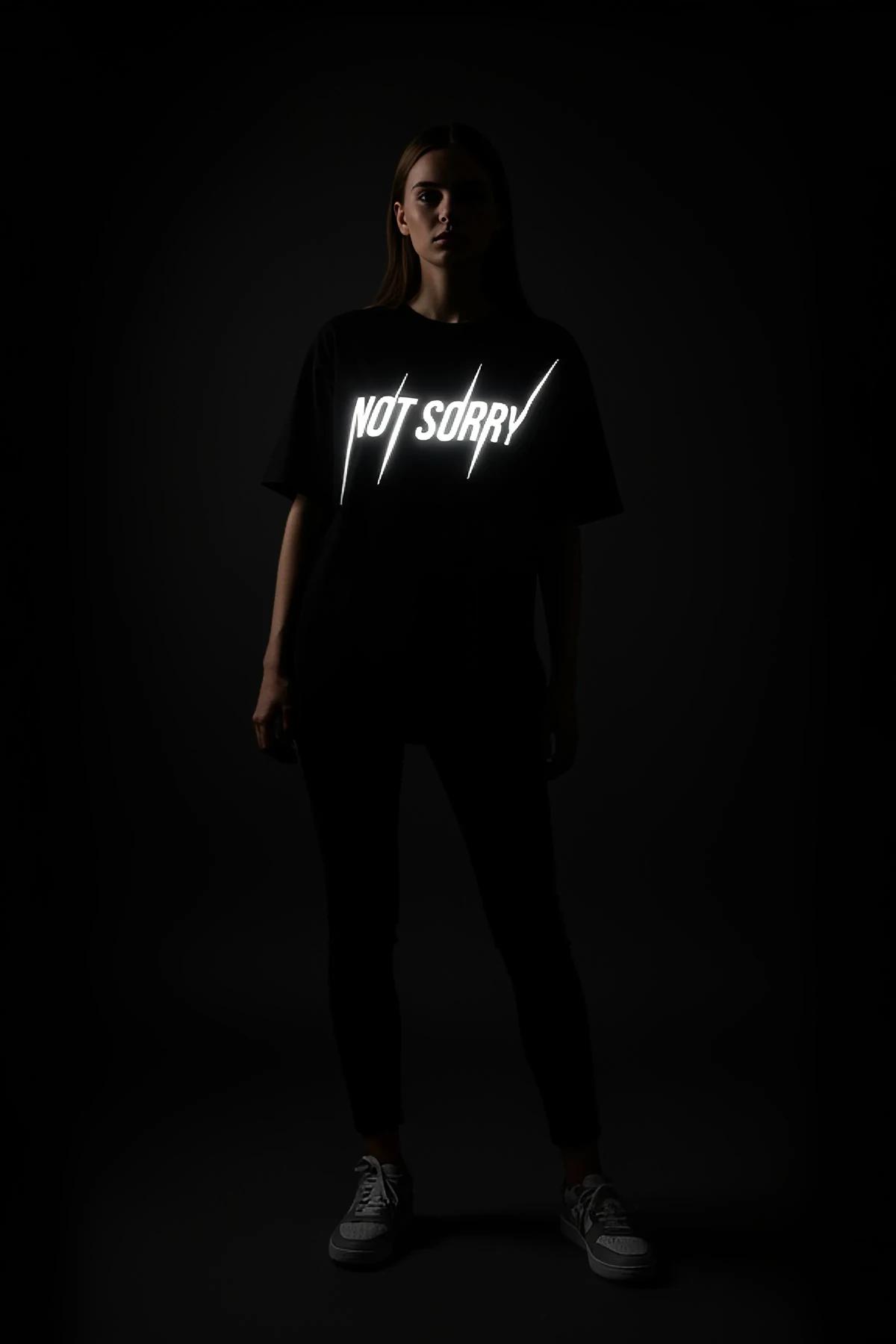 NOT SORRY reflektörlü ön baskılı siyah oversize tişört karanlıkta parlayan görünüm